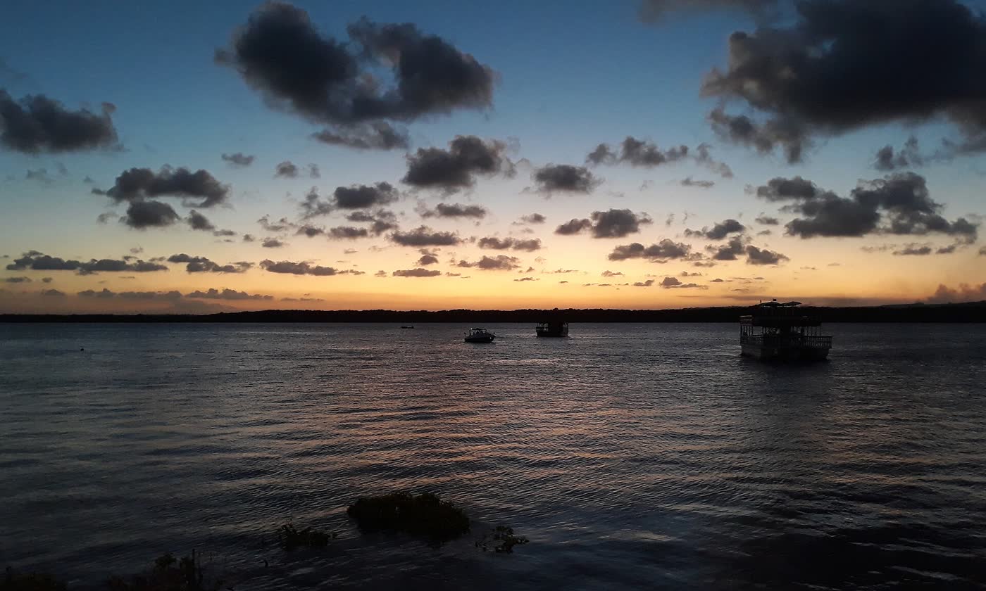 Pôr do sol alaranjado sobre o rio Paraíba na praia do Jacaré, em Cabedelo