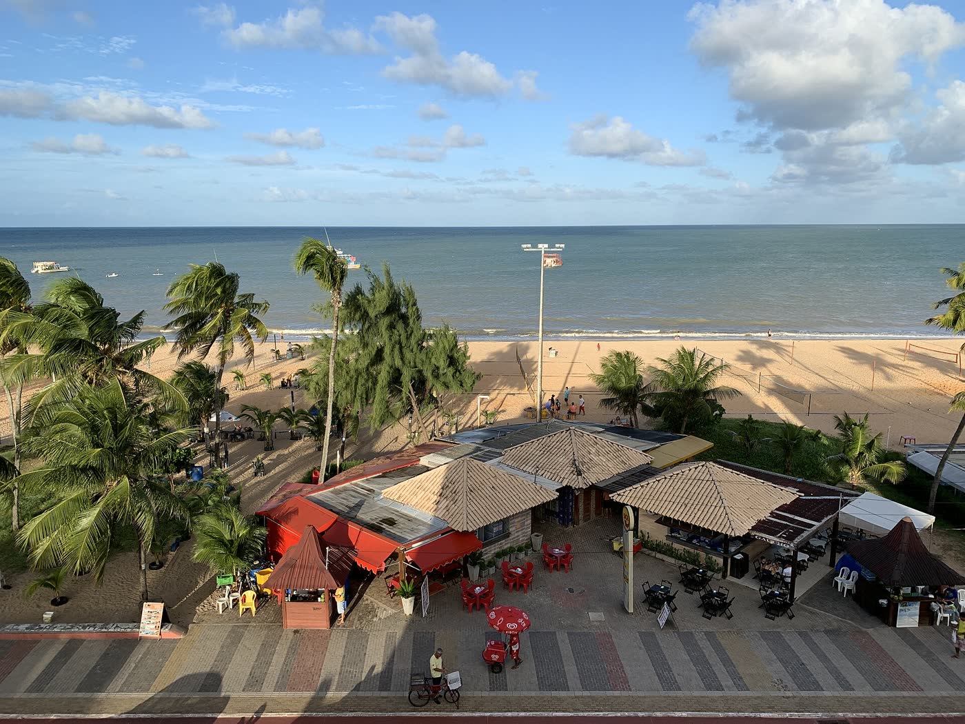 Vista aérea da praia de Tambaú, em João Pessoa, com mar azul-turquesa e orla arborizada